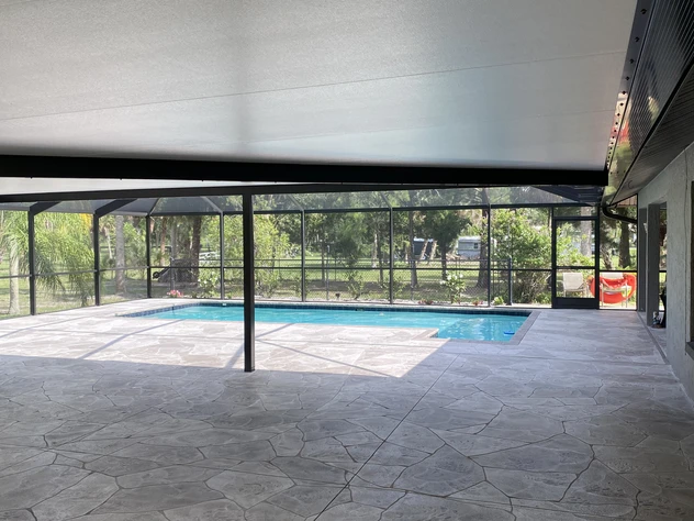 Modern outdoor patio featuring durable insulated aluminum panels, installed by AlumiPro, providing shade and energy efficiency by the poolside.